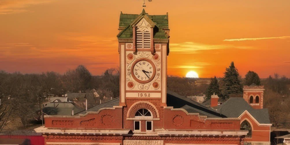 The Clock Tower Lofts tower glowing at sunset in downtown Stuart, Iowa